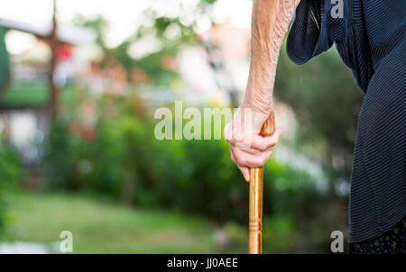 Senior woman walking with a cane outdoors Stock Photo