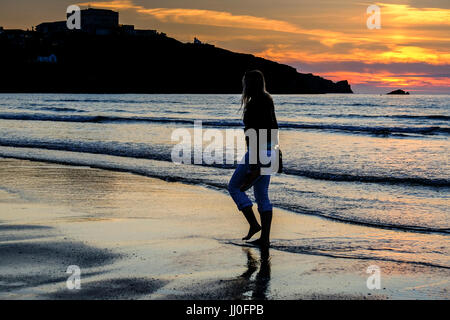 woman walking along the beach at sunset Stock Photo