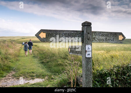 A wooden signpost on a footpath giving directions to West Pentire and Porth Joke Beach.  Polly Joke in Newquay, Cornwall. Stock Photo