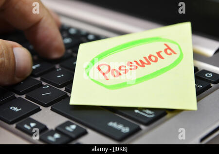 Password written on yellow note on black keyboard Stock Photo