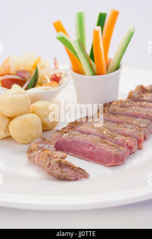 sirloin grilled serve with somtum, sticky rice ball and vegetales in thai style Stock Photo