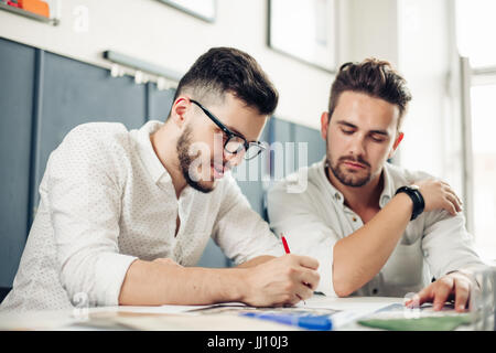 two handsome men architect looking at plans Stock Photo