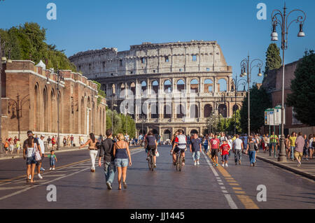 ROME, ITALY - SEPTEMBER 5, 2010: People are walking along the Via dei Fori Imperiali in Rome, enjoying the late afternoon sun. The Colosseum stands ta Stock Photo