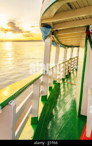 PORTO VELHO, BRAZIL - JUNE 17, 2017: Landscape of a on board traditional and classic boat ride at Rio Madeira river on sunset. Boats departs from Estr Stock Photo