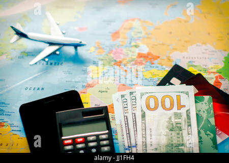 Travel planning with US dollar banknotes, calculator, smartphone and airplane on world map – finance, budget and tourism concept. Stock Photo