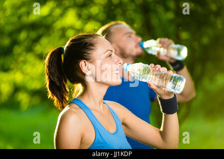 Man and woman drinking water from bottle after fitness sport exercise Stock Photo