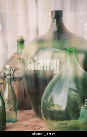 Old empty wine bottles behind the glass with street reflection Stock Photo