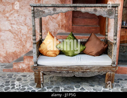 Decorative outdoor wooden couch with pillows. Stock Photo