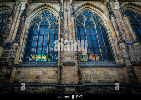 Light from the interior of St Vitus Cathedral in Prague illuminating the stained glass windows on the exterior Stock Photo