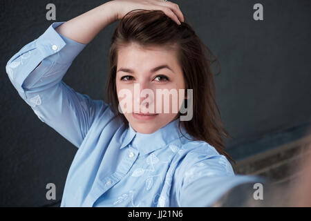 Girl makes selfie photo. Close up portrait, view of the camera