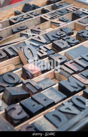 Vintage wooden typeset letters in a printers tray at a flea market with ink in an abstract letter pattern Stock Photo