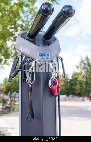 Tools attached by steel cables for repairing bicycles on a bike rack at a roadside filling station in Ireland.