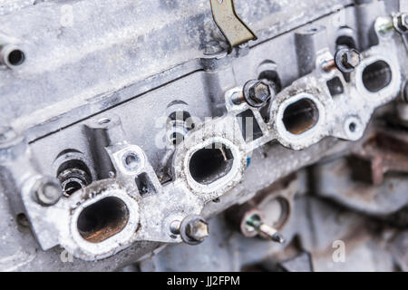 Exhaust gas exit ports on an old engine block with the exhaust manifold removed. Stock Photo