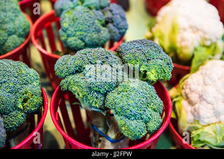 Closeup of broccoli and cauliflower bunches in baskets on display in farmers market