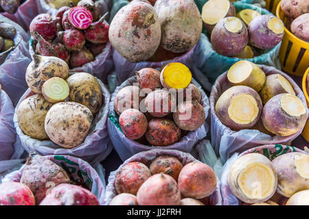 Closeup of different types of turnips root vegetables on display in baskets at farmers market Stock Photo