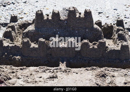 A little beach sandcastle built on the shore of the Black Sea made of fine sand and decorated with some seashells. Stock Photo