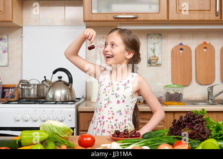 child girl with fruits and vegetables in home kitchen interior, healthy food concept Stock Photo