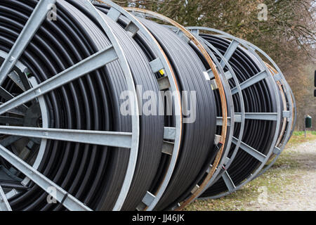 Steel roller with fiber optic cables for the installation of data cables on a construction site. Stock Photo