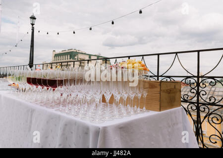 Wineglasses for the wedding catering on the table outdoors Stock Photo