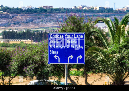 Malta, Bugibba: Blue road sign showing the way to some popular tourist destinations. Stock Photo