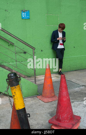 16.07.2017, Singapore, Republic of Singapore, Asia - A young man is seen playing a computer game on his smartphone in Singapore's Chinatown district. Stock Photo
