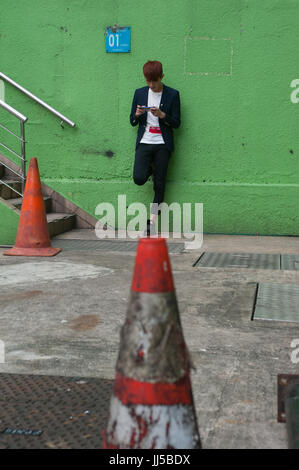 16.07.2017, Singapore, Republic of Singapore, Asia - A young man is seen playing a computer game on his smartphone in Singapore's Chinatown district. Stock Photo