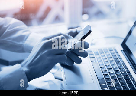 mobile technology concept, close up of hands holding smartphone, toned in blue Stock Photo
