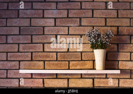 simple interior design, flower pot on the shelf on brick wall with copyspace Stock Photo