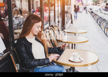 young woman using digital tablet computer in street cafe in Europe Stock Photo