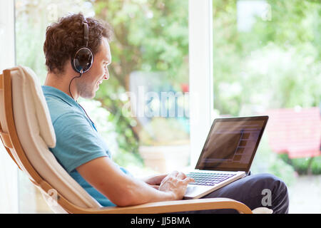 man watching funny videos on internet and laughing at home Stock Photo