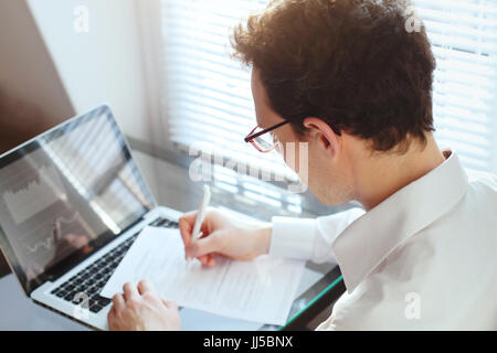 businessman manager working with financial data and papers in the office, writing report Stock Photo