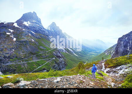 Trollstigen in Norway, tourist looking at mountain road in stunning beautiful landscape Stock Photo