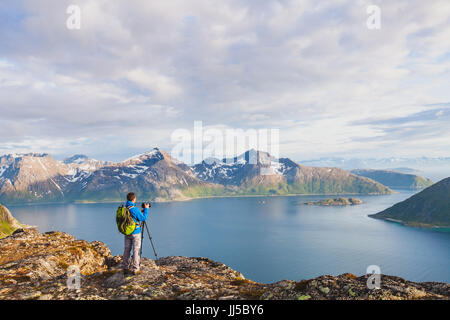 nature landscape photographer using tripod and dslr camera to capture beautiful panoramic landscape, travel photography Stock Photo