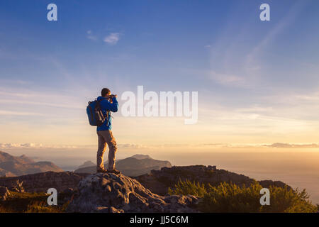 nature photographer traveler taking photo of beautiful landscape from top of the mountain Stock Photo