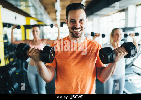 Group of friends exercising together in gym Stock Photo
