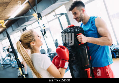 Picture of woman wearing boxing gloves and her trainer Stock Photo