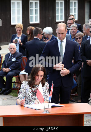 The Duke and Duchess of Cambridge sign the visitors book during their visit to the former Nazi concentration camp at Stutthof, near Gdansk, on the second day of their three-day tour of Poland. Stock Photo