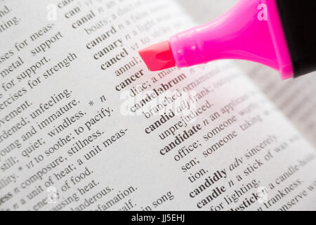 Cropped image of pink felt tip pen with cancer text on dictionary page Stock Photo
