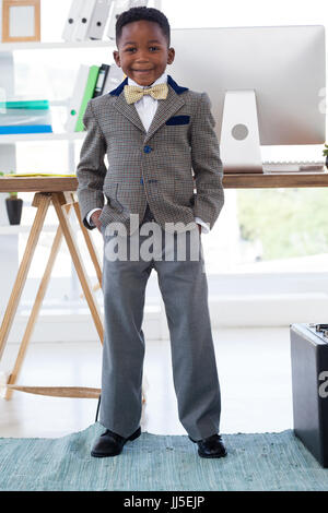 Businessman with hands in pockets standing in office Stock Photo