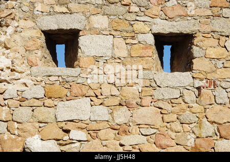 Narrow windows on a medieval wall to look at the enamy without been shot. Stock Photo