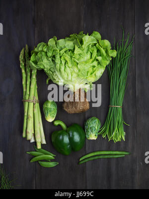 Fresh green organic vegetables on black wooden vintage table.Top view Stock Photo