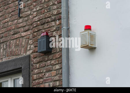 Two alarm systems with warning lights on a house wall Stock Photo