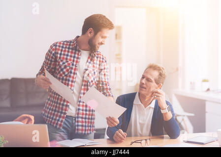 Positive colleagues helping each other in the office Stock Photo