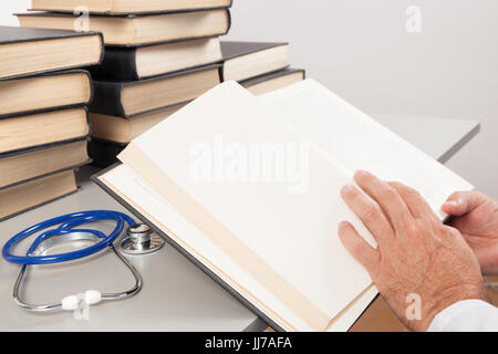 Doctor specialist reading scientific medical books and textbooks in the library. Stock Photo