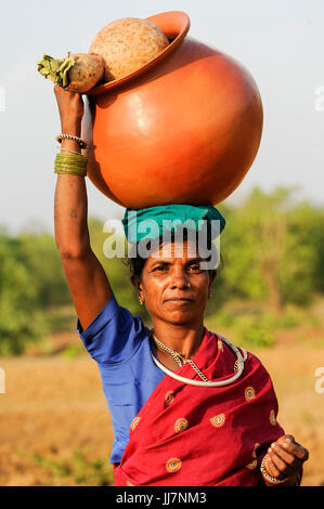 INDIA Chhattisgarh, Bastar, tribal Gond woman with clay pot coming from market / INDIEN Chhattisgarh , Bastar, Adivasi Frau des Gond Stammes, indische Ureinwohner, mit Ton Krug Stock Photo