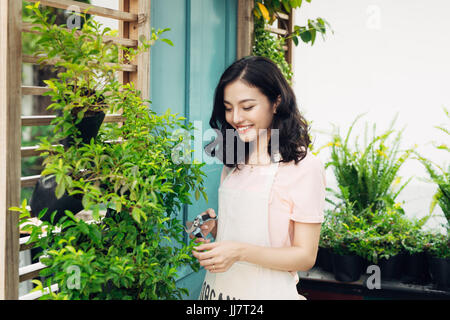 https://l450v.alamy.com/450v/jj7t24/cute-asian-woman-gardener-cutting-plants-with-garden-scissors-in-greenhouse-jj7t24.jpg