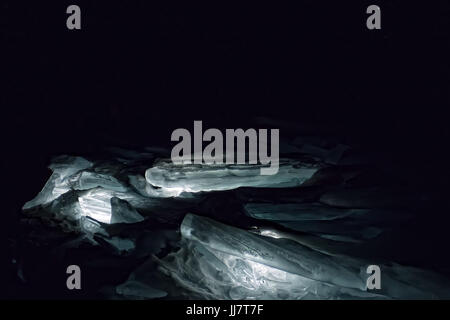 Luminous hummocks of the blue ice of Lake Baikal in the dark. Stock Photo