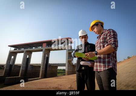 Business men meeting with Engineers and foremen are standing reading reports on construction sites. Stock Photo