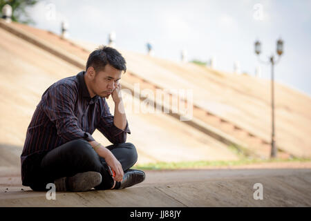 Depressed men with businessman sitting sadly under a bridge. Stock Photo