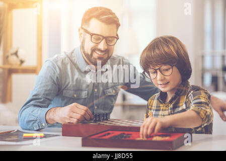 Delighted happy man putting chess pieces on the chessboard Stock Photo